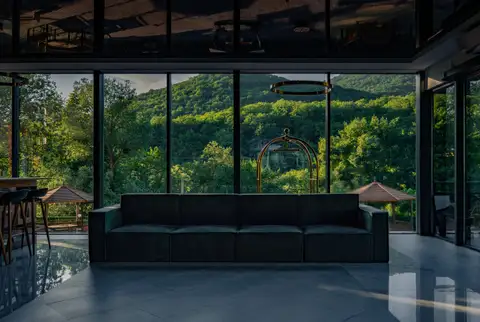 A lounge with a glass wall and a forest view